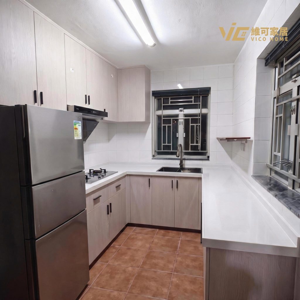 hk-custom-kitchen-service 21 米白色廚櫃配白色石英檯面,L 型佈局,黑色把手,可見雪櫃及窗景。