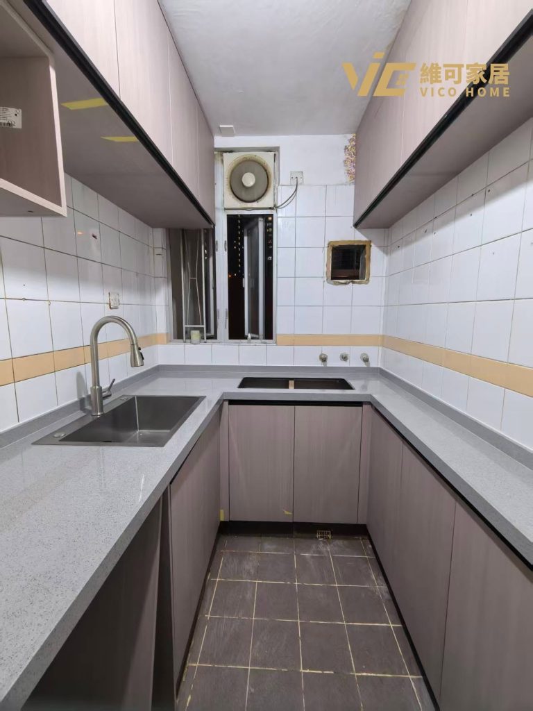 hk-custom-kitchen-service 12 灰色無手把廚櫃配石英檯面,L 型佈局,設抽氣扇,窗戶透光。