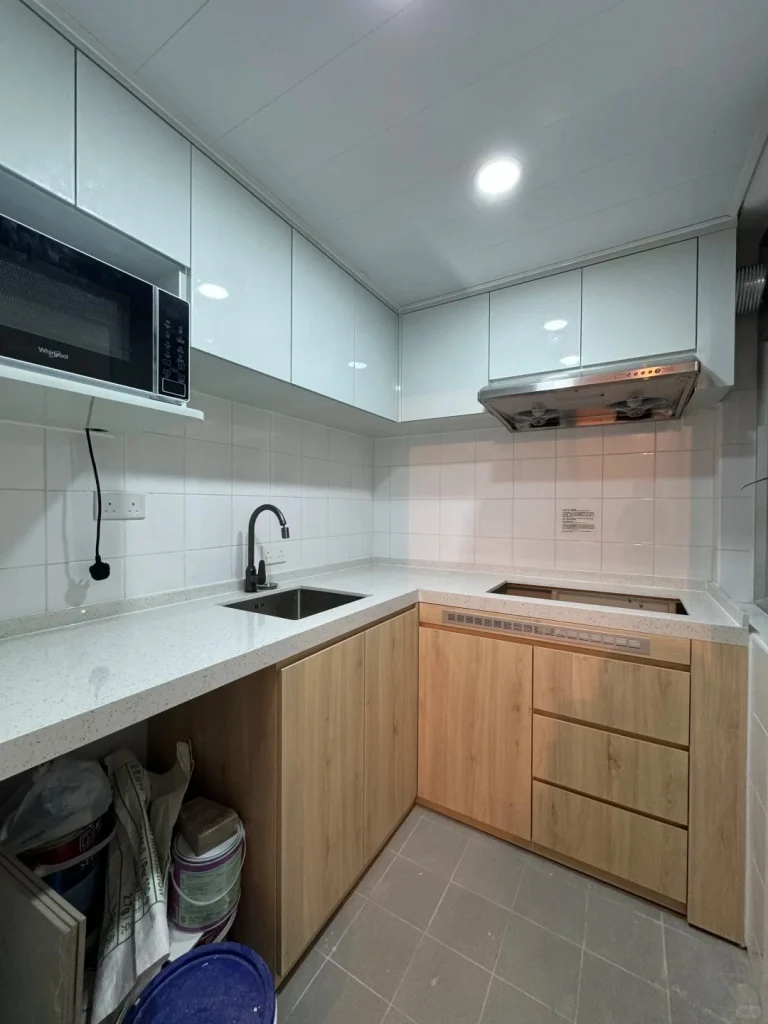 hk-custom-kitchen-service 22 米白色無手把廚櫃配石英檯面,L 型佈局,微波爐與抽油煙機內嵌。