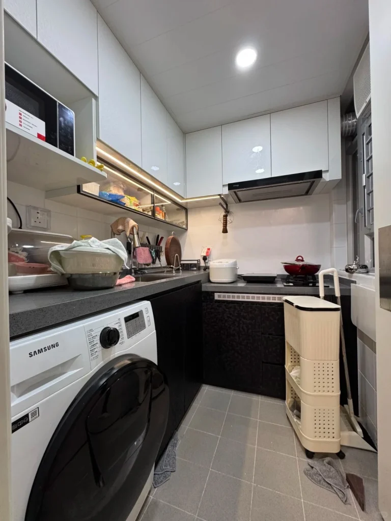 hk-custom-kitchen-service 6 白色無手把廚櫃配黑色石英檯面,L 型佈局,洗衣機、電飯煲及抽油煙機。