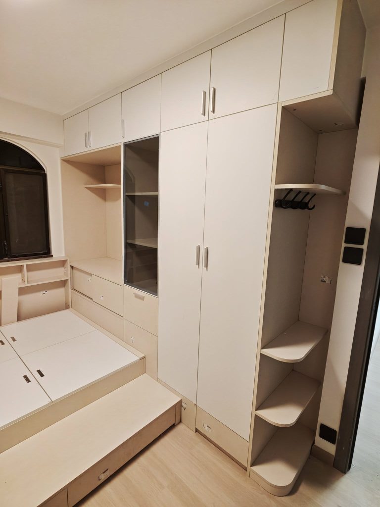 hk-custom-furniture-guide 5 米白啞光到頂衣櫃連地台床,拱形窗位順著牆身收口,門板邊緣膠線細緻。