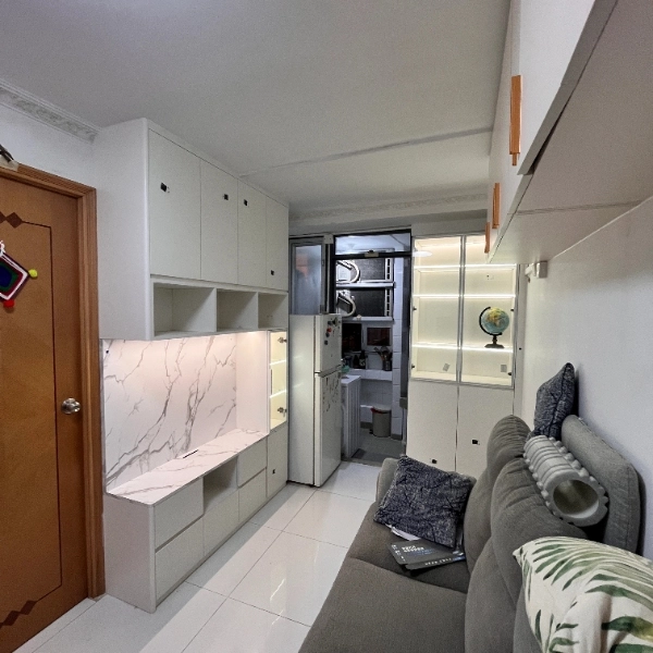 White kitchen cabinets with marble counter, sofa and glass-door fridge