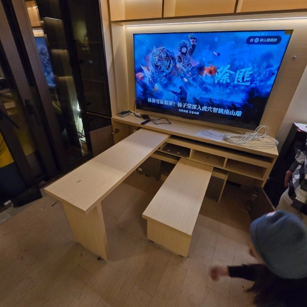 Light wood L-shaped desk and low cabinet with large TV