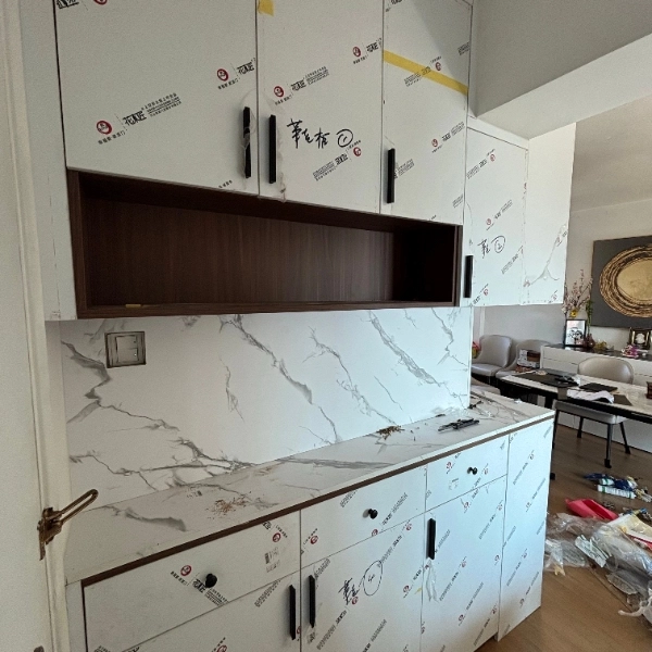 White cabinets with marble-pattern back panel and open shelving