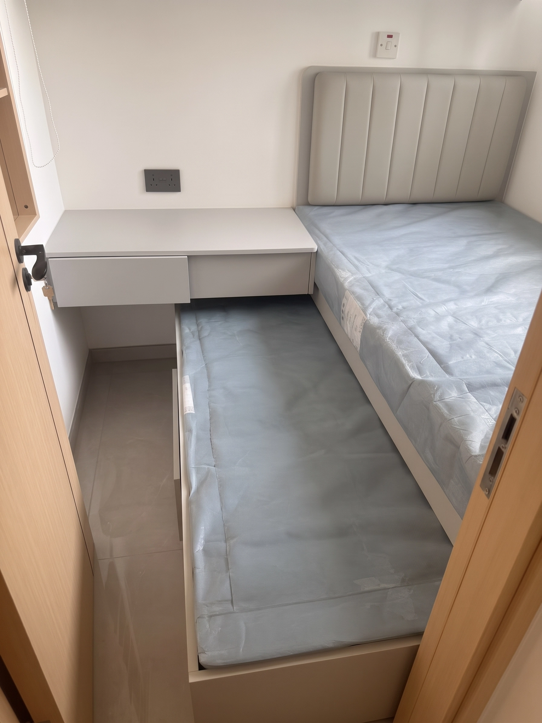 Yu Hing Court bedroom: Custom platform bed with upholstered headboard, pull-out drawers, and integrated desk