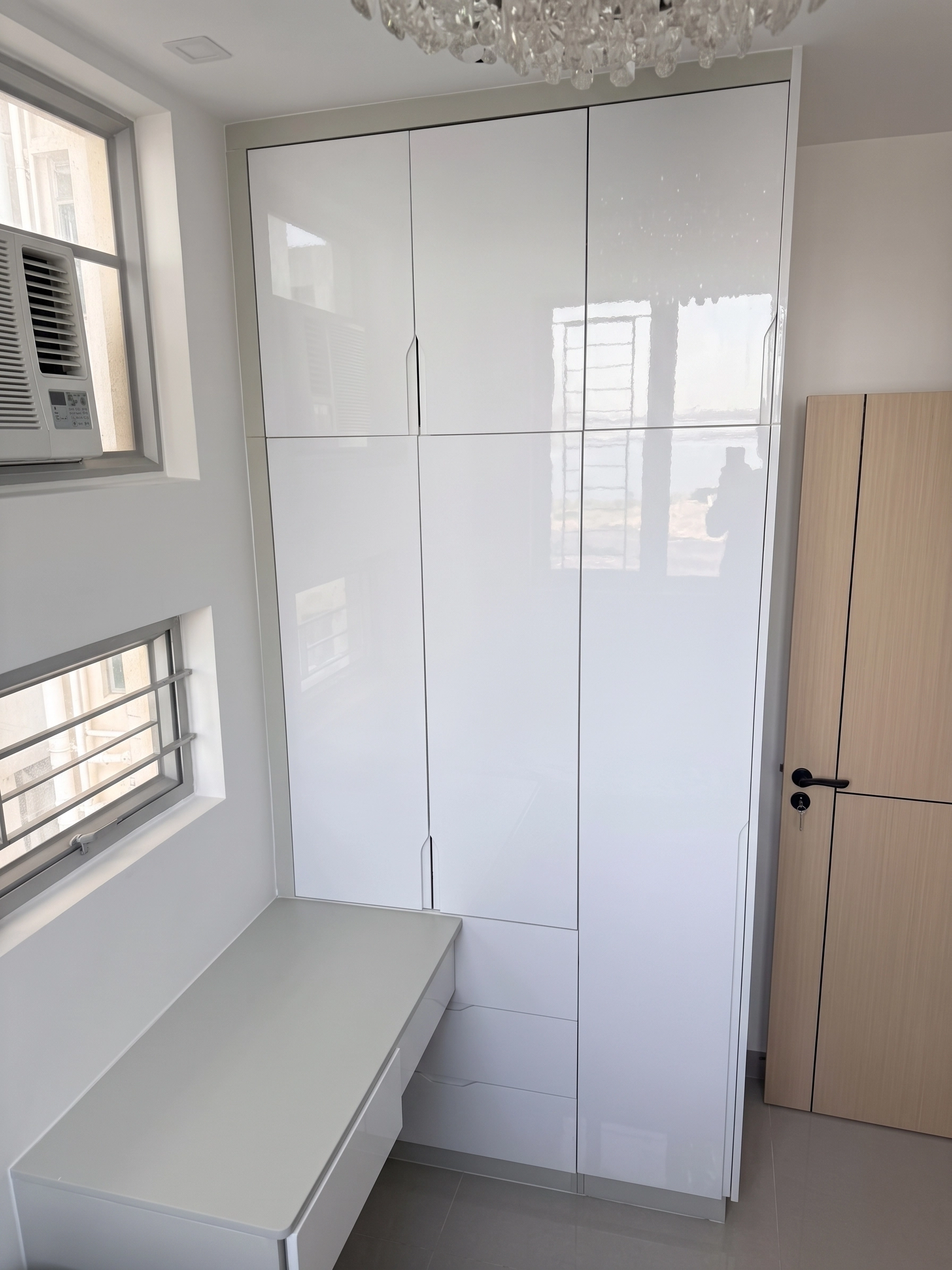 Yu Hing Court bedroom: Full-height high-gloss white wardrobe connected to a bay window desk