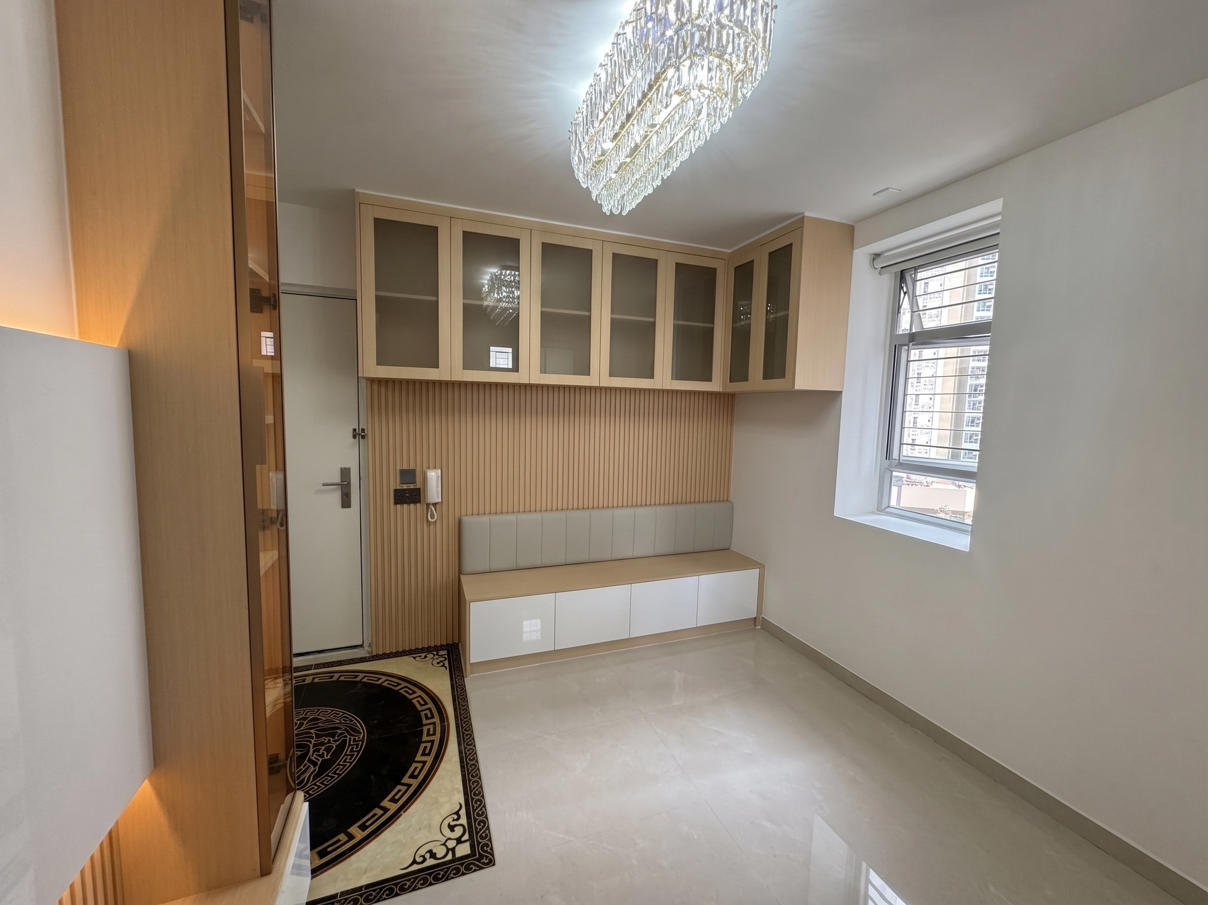 Yu Hing Court entryway showcase: Full-height glass cabinet, wood wall panelling with built-in shoe bench