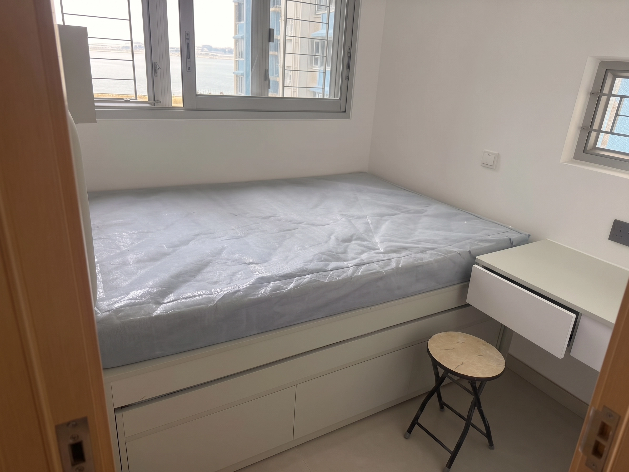 Yu Hing Court secondary bedroom: Storage platform bed with built-in cupboards and bay window desk
